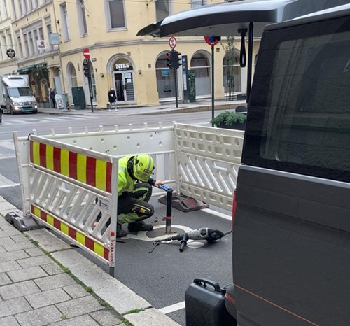 Worker installing sensors in disabled parking spot