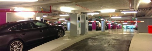 Car enters parking garage equipped with barriers and ticket machines