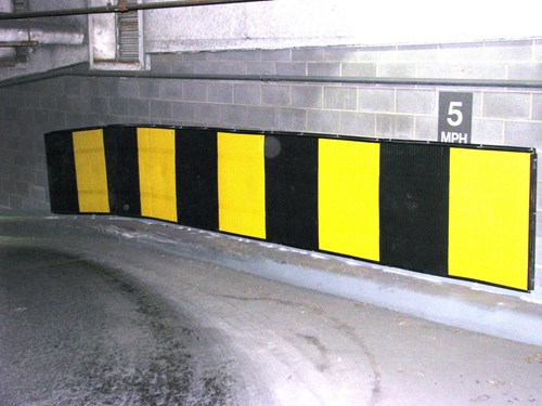 Yellow protection placed on the wall in a parking garage