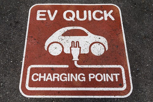 Sign on tarmac showing an EV Charging spot