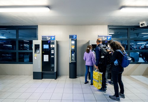 People queue to use a parking machine
