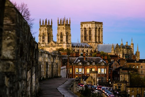 York's city walls with the Minster in the background and a line of traffic at dusk
