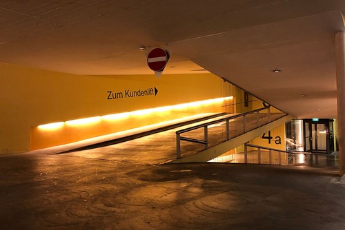 Interior of a parking garage showing ramps and no entry sign