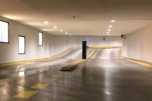 Entry and exit lane of an indoor parking garage showing yellow barrier