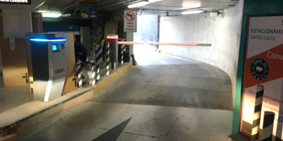 Entry ramp of a parking garage with barriers and ticket machines