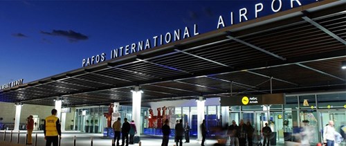 Front of Pafos International Airport at night time, with the name in letters on the facade